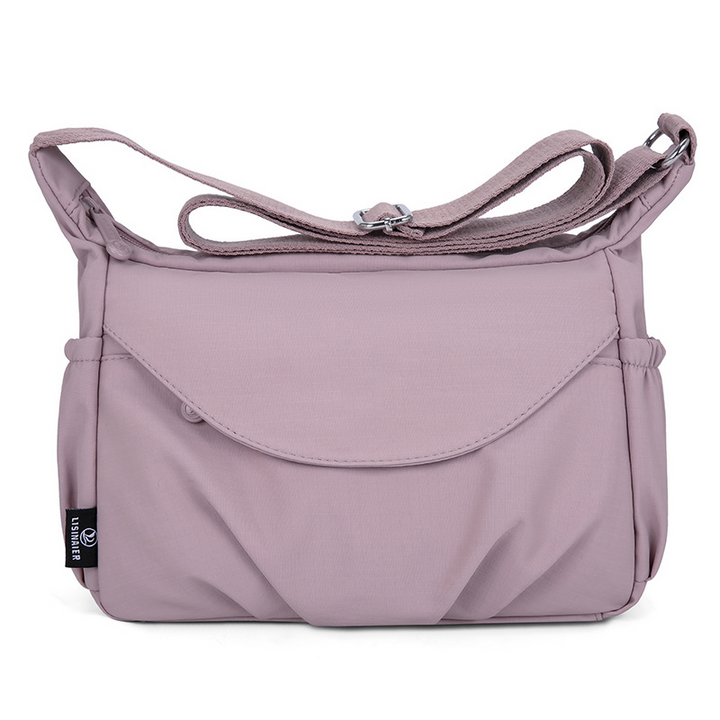 Crossbody skuldertaske med justerbar rem, kan bæres på flere måder.