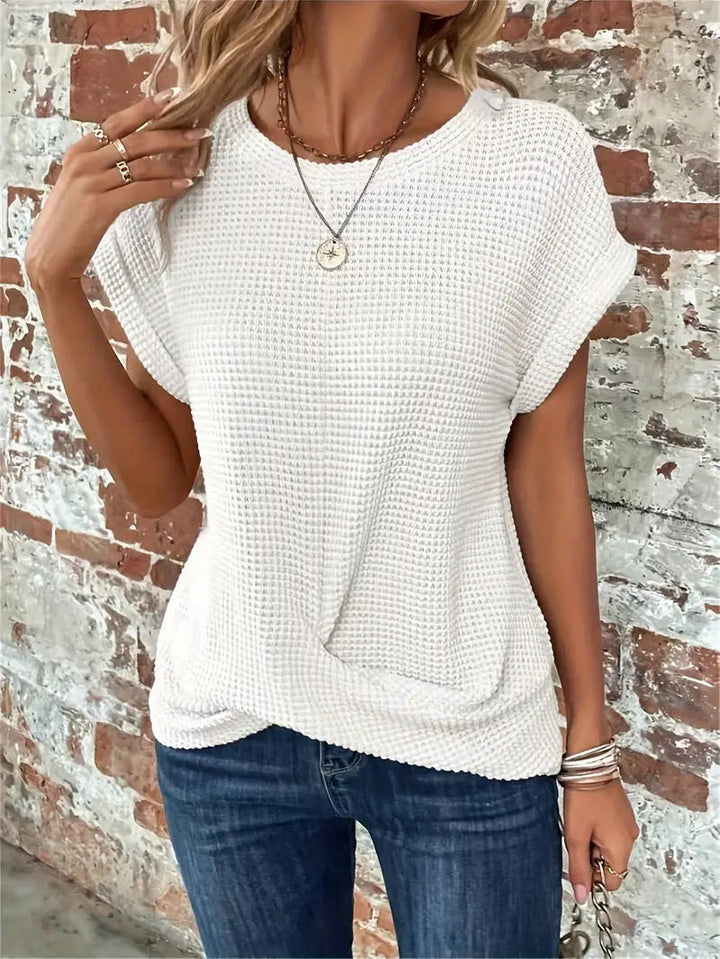 Afslappet og komfortabel vaffelstrik top til kvinder med stilfuld front twist detalje. Perfekt til hverdagen.