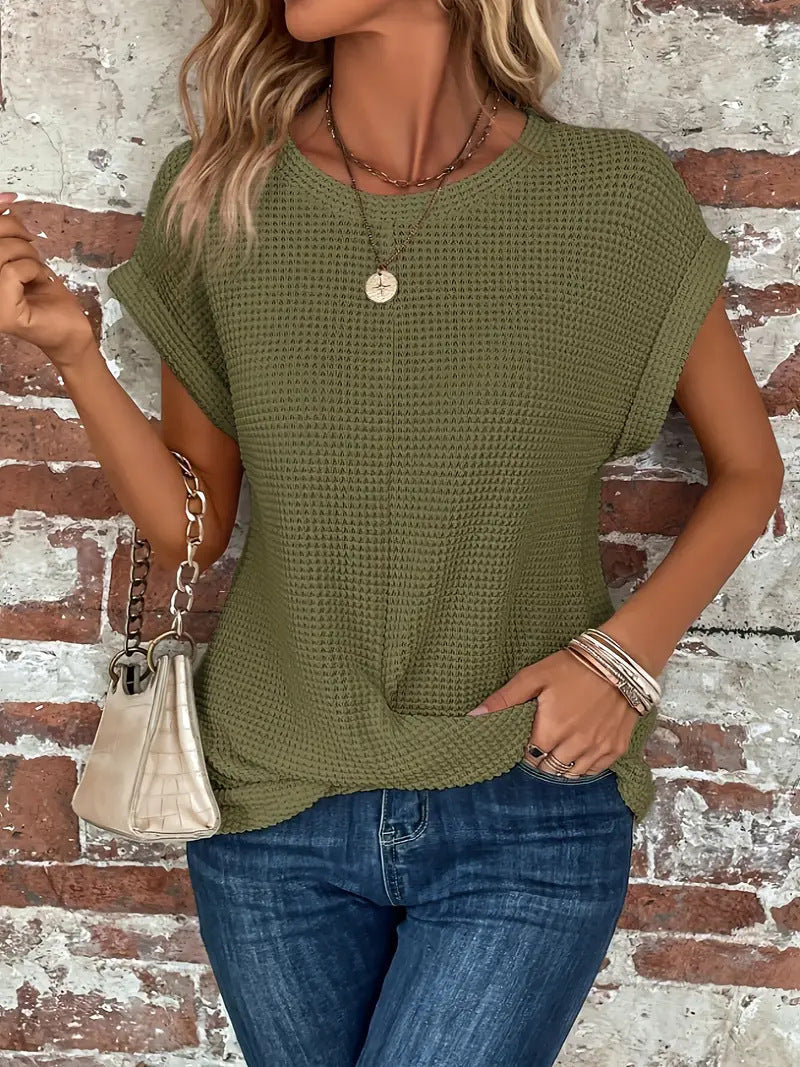 Let sommertop i vaffelstrik til kvinder. Med rulleærmer og twist for et friskt, stilfuldt hverdagslook.