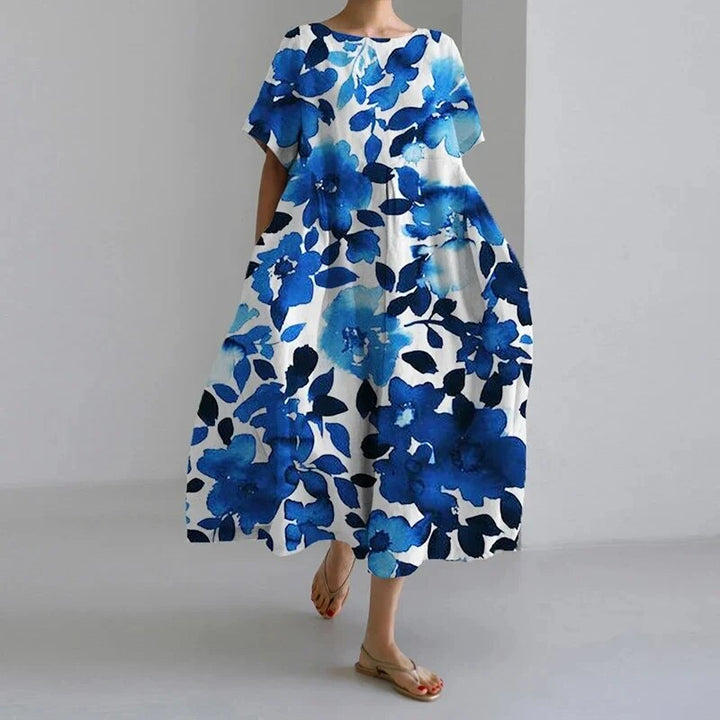 Model iført en løstsiddende, blomstret boho damekjole. Afslappet og feminin stil til forår/sommer.