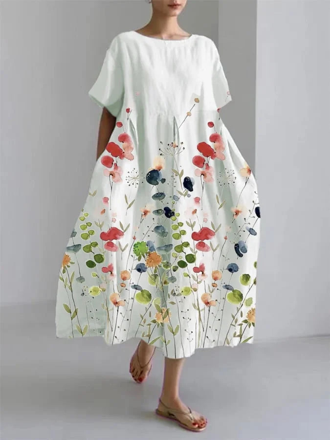 Nærbillede af stoffet: Blomstret mønster på en løstsiddende damekjole i boheme stil. Detaljeret.