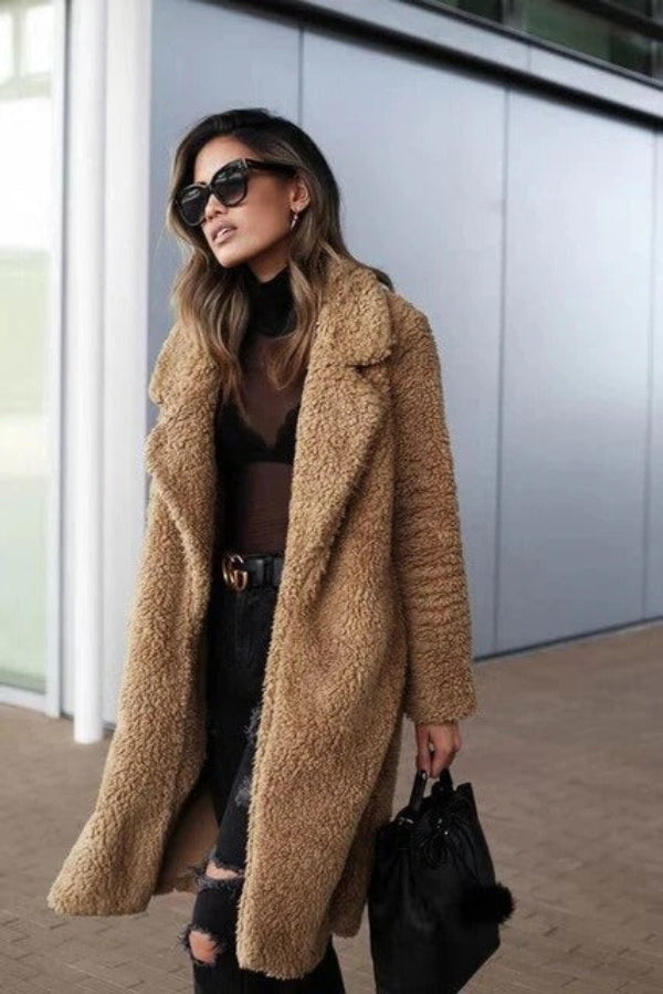 Elegant lang damefrakke med teddy plys-look. Stilfuld og varm vinterjakke til kvinder. Perfekt som mode overtøj.
