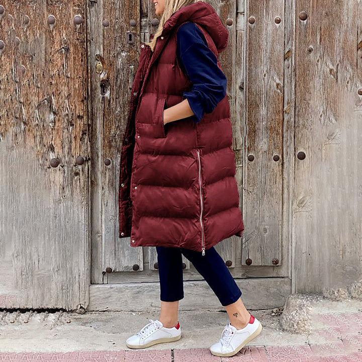 Brun lang puffer vest til damer med hætte. Komfortabel og chik til hverdagsbrug i de kølige måneder.