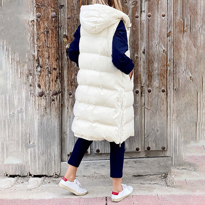 Trendy hvid lang hættevest til damer. Varm puffer vest perfekt til et sporty og chic look.