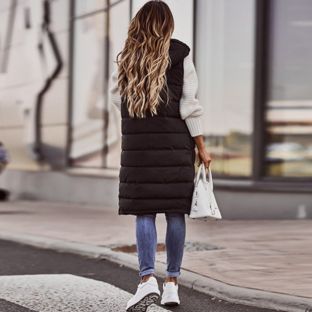 Klassisk sort lang puffer vest til kvinder. Hættevest designet for optimal varme og stil i koldt vejr.