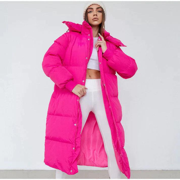 Trendy lang sort pufferjakke til damer med hætte. Varm og stilfuld vinterjakke til streetwear og hverdag.