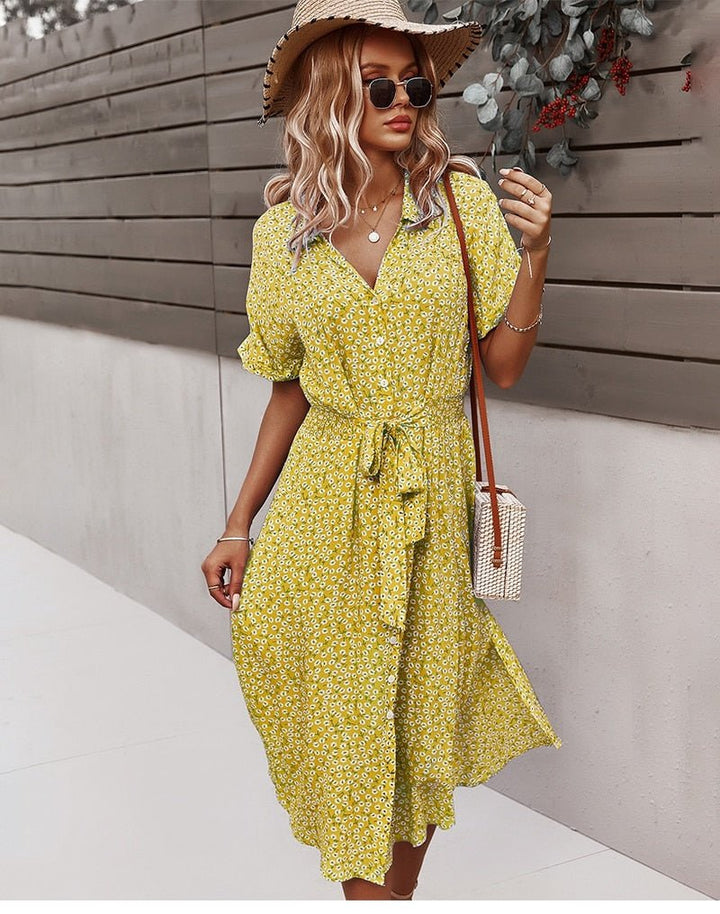 Bagside af elegant sommerkjole med blomsterprint. Midi-længde og bindebånd detalje.
