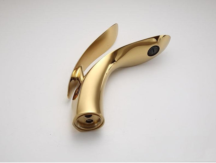 Elegant guld håndvaskarmatur med buet design, perfekt til et luksuriøst badeværelse. Moderne vandhane.