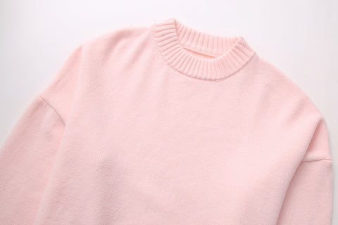 Detaljeret billede af en lyserød dame sweater, løs pasform, rund hals og lange ærmer. Komfortabel pullover.