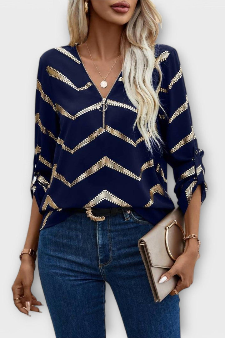 Elegant mørkeblå damebluse med zigzagmønster og V-udskæring, vist på model. Ideel til både fest og hverdag.