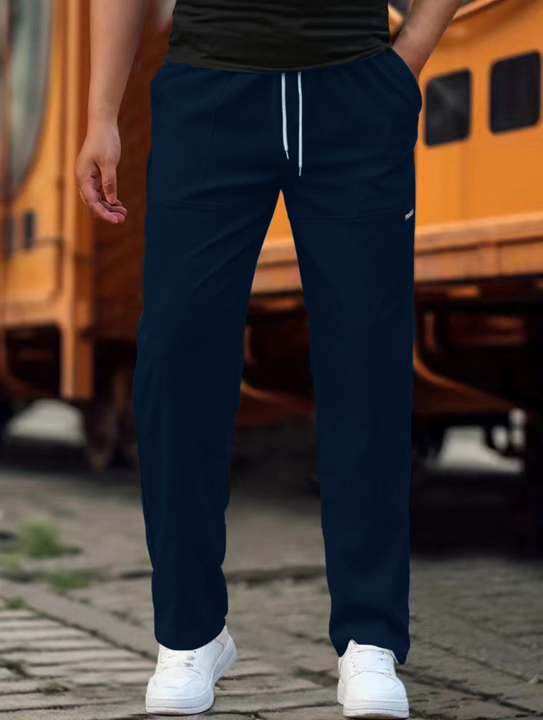 Detaljebillede af lommen på herre joggingbukser, fremhæver praktisk design og kvalitet.