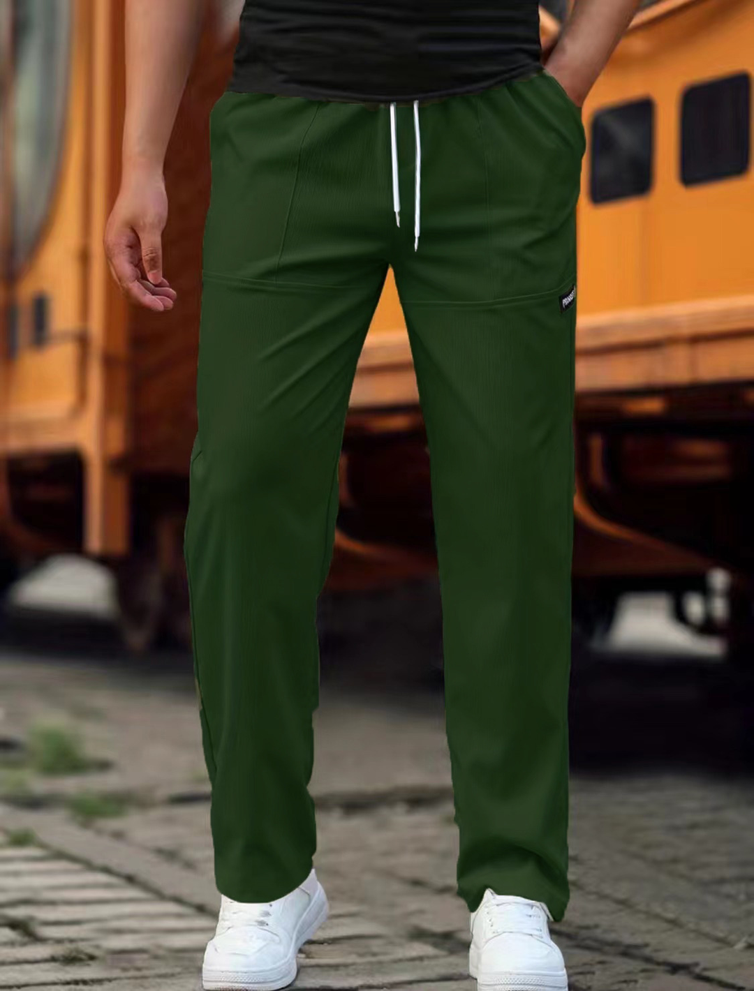 Mand iført sorte joggingbukser, kombineret med en T-shirt for et komplet afslappet hverdagslook.