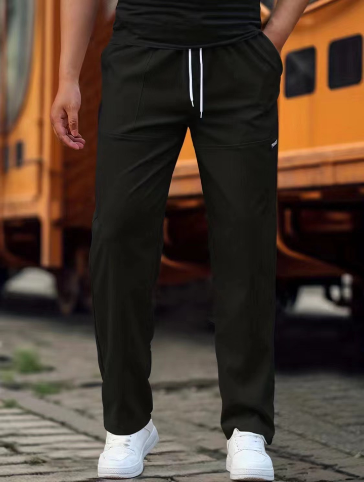 Pænt foldede herre sweatpants, klar til brug, symboliserer letpleje og høj kvalitet.