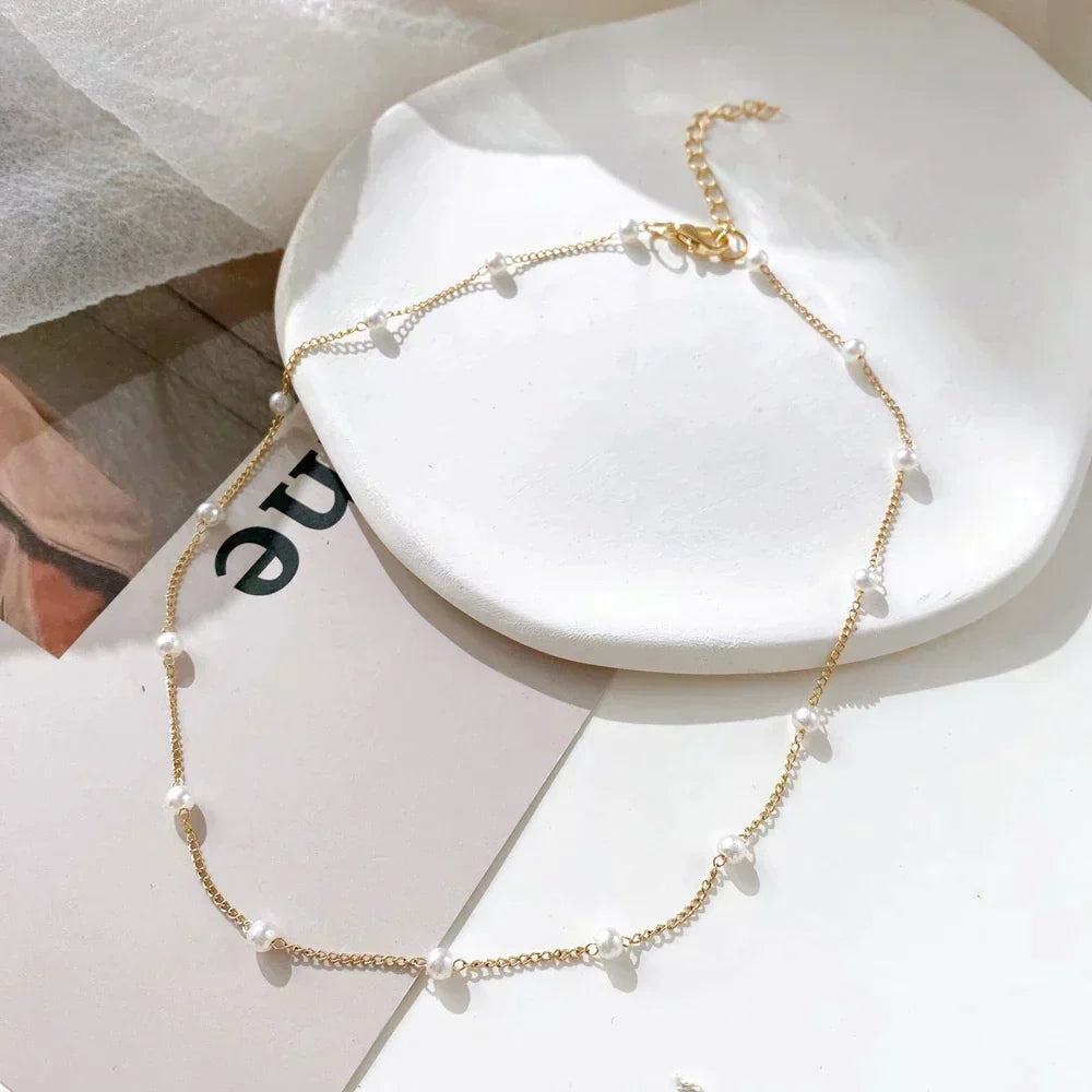 Delikat guld choker med fine perler, justerbar for perfekt pasform. Ideel til lag-på-lag styling.