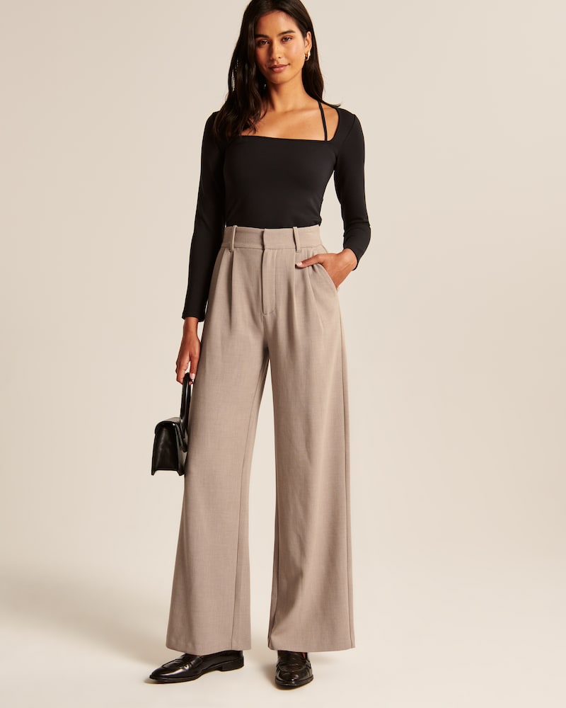 "Model iført beige polyester bukser med høj talje og bredde ben, ideel til professionelt og tidløst look."