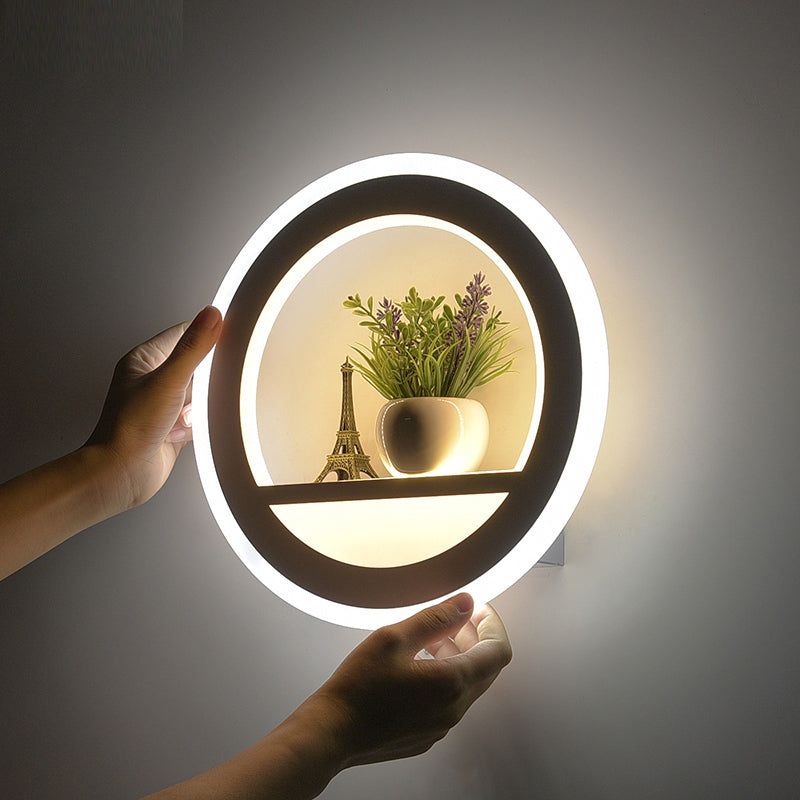 Detalje af den moderne runde LED væglampe med den indbyggede hylde, der viser dens multifunktionelle design.