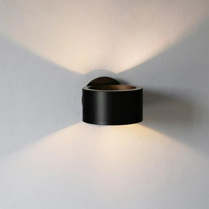 Elegant design væglampe i sort og guld, perfekt til moderne boligindretning.