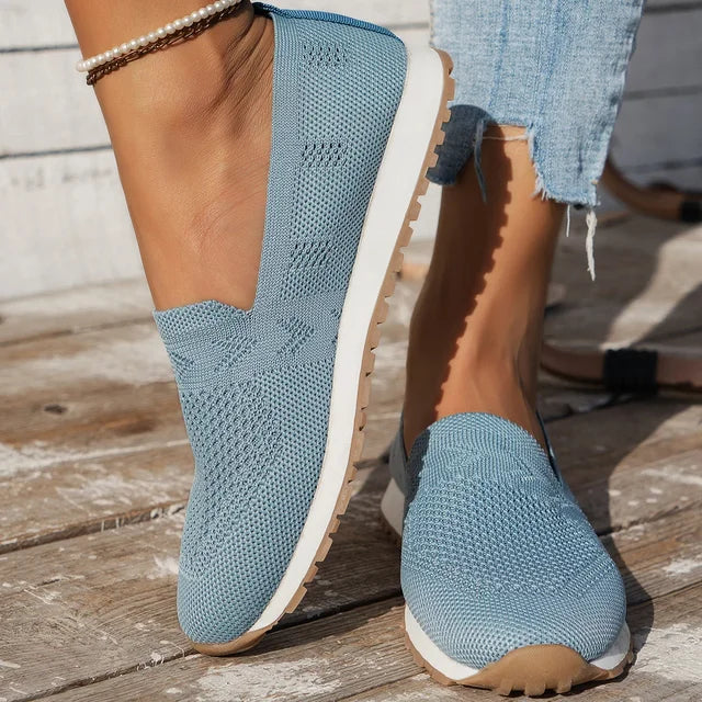 "Ortopædiske dame slip-ons i marineblå med åndbar fodseng, let slip-on design og elegant stil."