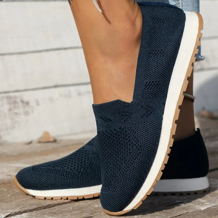 "Ortopædiske dame slip-ons i marineblå med åndbar fodseng, let slip-on design og elegant stil."