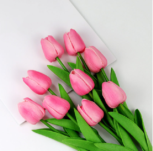 Kunstige tulipaner i en kurv, skaber hygge og varme i hjemmets indretning.