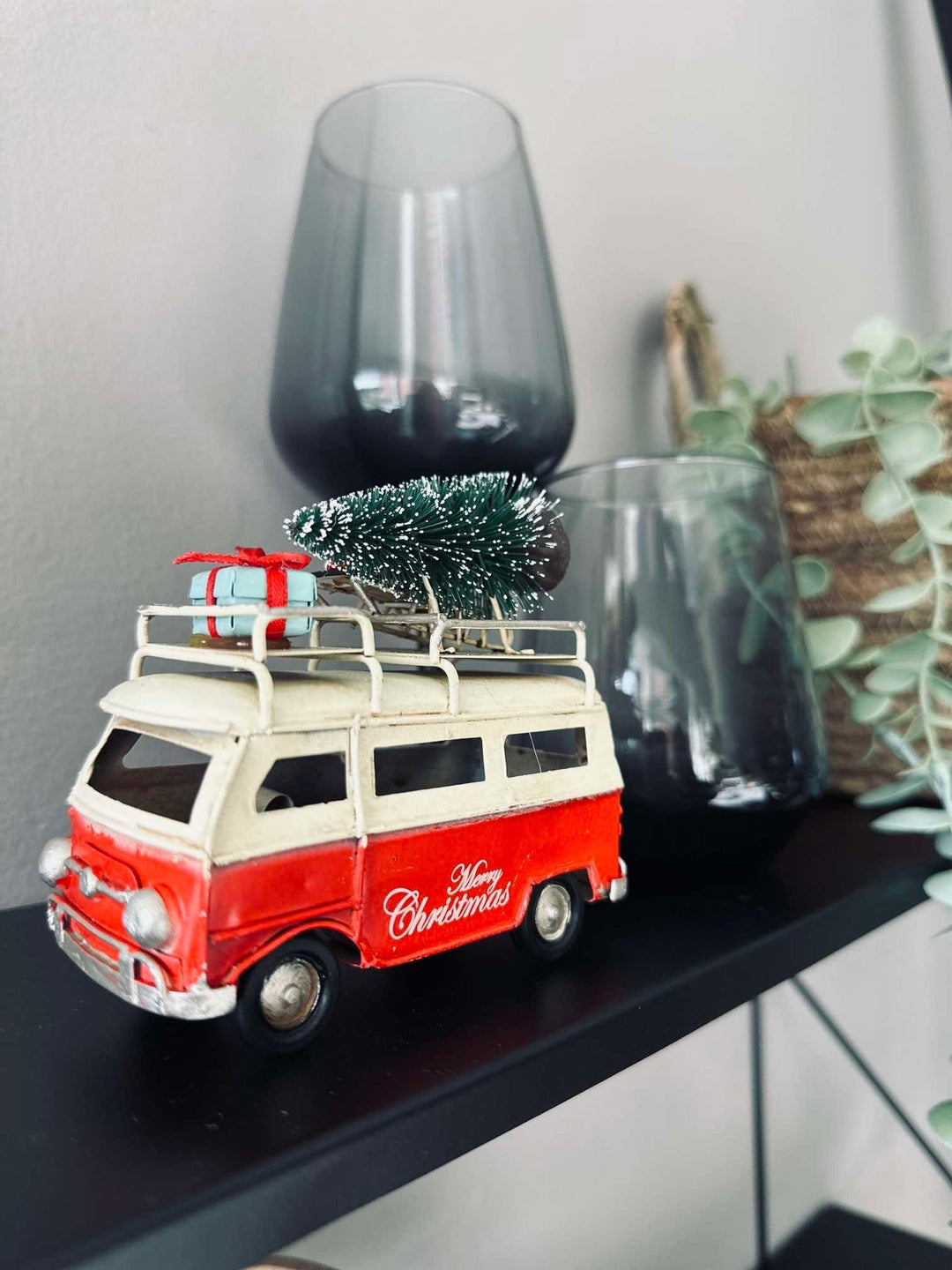 Dekorativ julebil i retro stil med grønt juletræ og farverige gaver – ideel til julen.