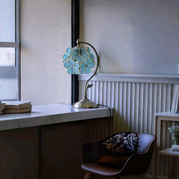 Blomster Tiffany bordlampe med justerbar højde og robust bronzefod, giver varm og indbydende lys.