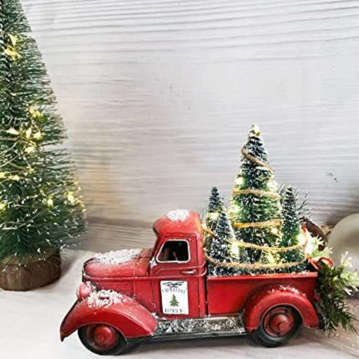 Håndlavet rød julelastbil med grønt juletræ. Rustik vinterpynt for en hyggelig og festlig julestemning.