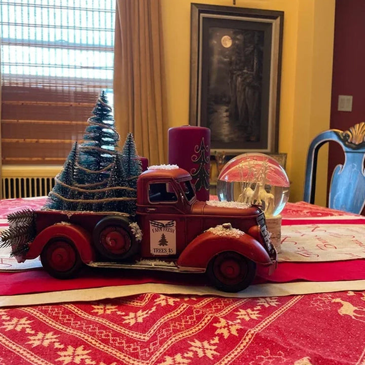 Dekorativ julelastbil i rustik rød, med et lille juletræ. Skab stemning med denne charmerende julepynt.