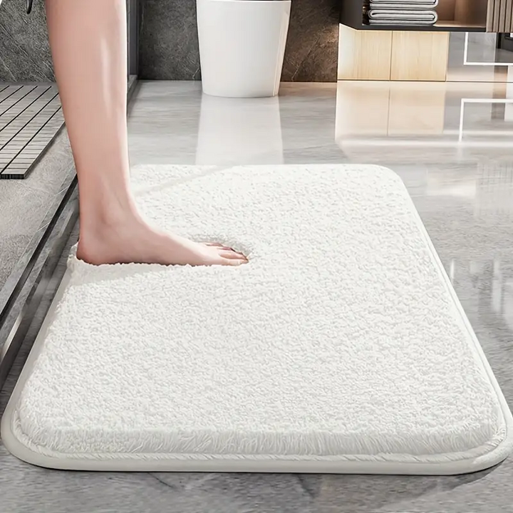 "Skridsikker rektangulær bademåtte med afrundede hjørner, bløde materialer i beige for komfort og stil i badeværelset."