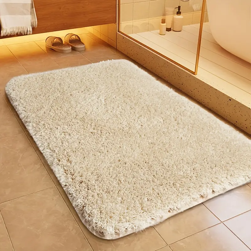 "Skridsikker rektangulær bademåtte med afrundede hjørner, bløde materialer i beige for komfort og stil i badeværelset."