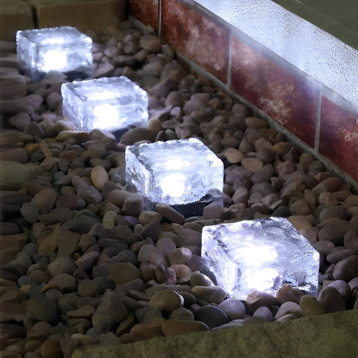 Solardrevet terninglampe lyser op i skumringen; skaber stemning i haven.