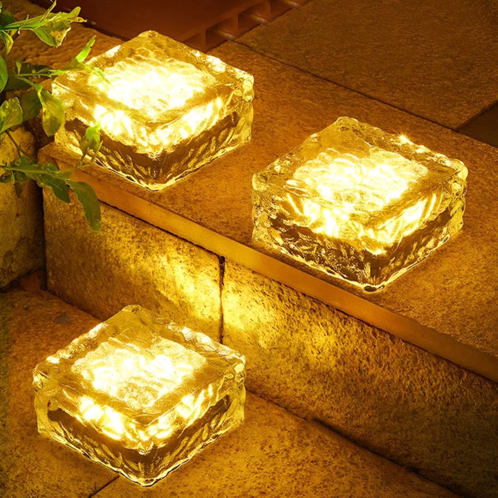 Detalje af terningformet solardrevet havelampe med klart LED lys.
