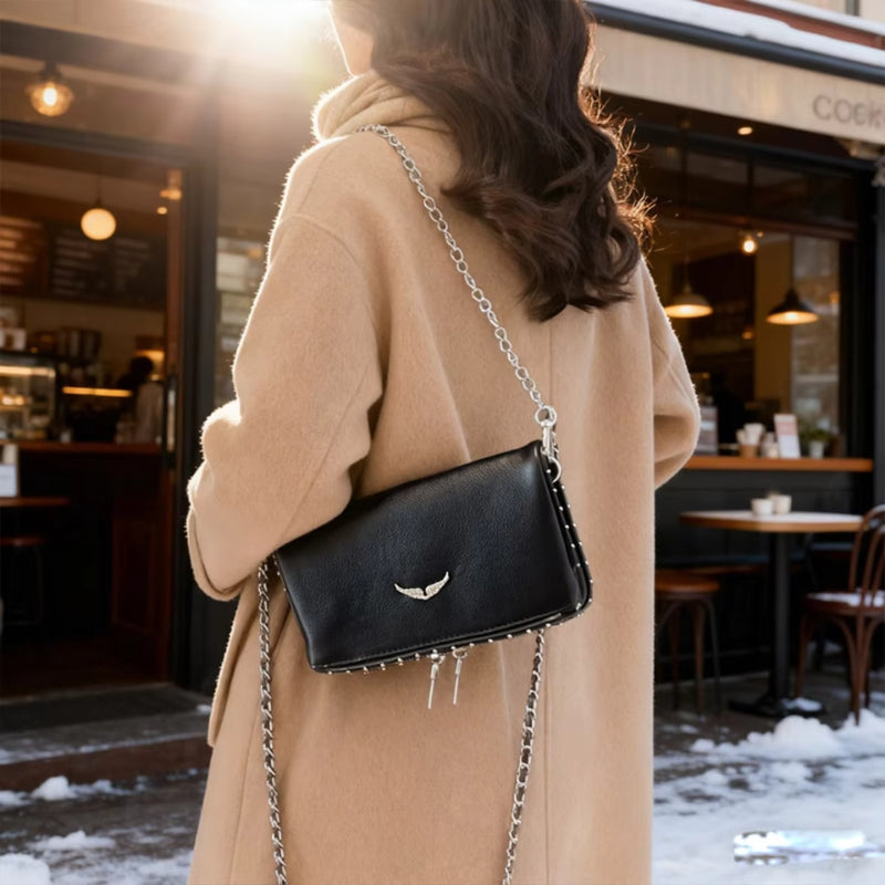 Elegant sort dame håndtaske bagfra. Viser den alsidige justerbare kæderem, perfekt til enhver lejlighed.
