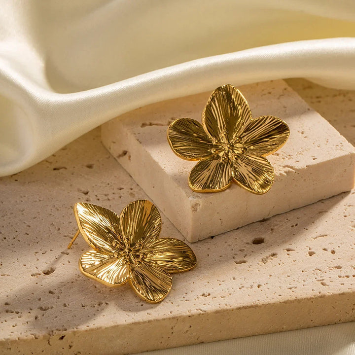 Nærbillede af vintage guld blomsterørering, viser fine detaljer og skinnende finish. Et unikt accessory.