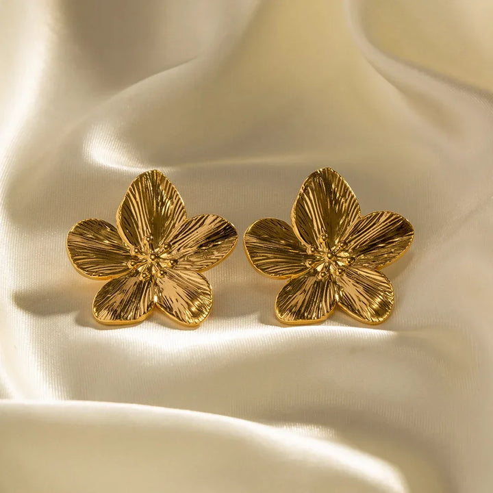 Stilfulde blomsterøreringe i guld, der elegant komplementerer ethvert outfit som et tidløst vintage smykke.