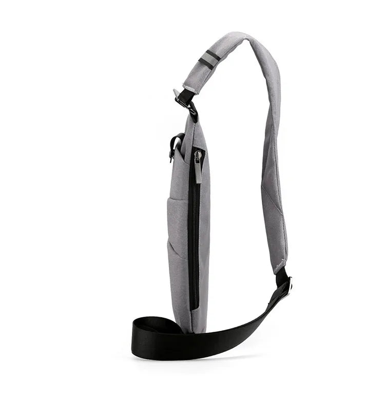 Grå mini crossbody taske med justerbar rem, tyverisikker og praktisk til eventyr eller daglig brug.